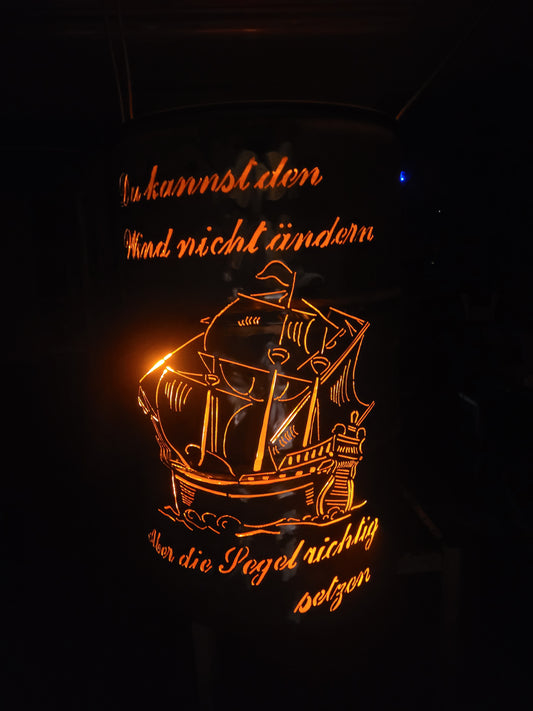 Feuertonne mit Schiff als Motiv und einem Schriftzug